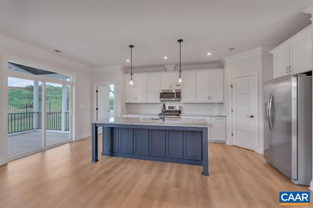 kitchen with a center island with sink, white cabinetry, appliances with stainless steel finishes, decorative light fixtures, and light hardwood / wood-style floors