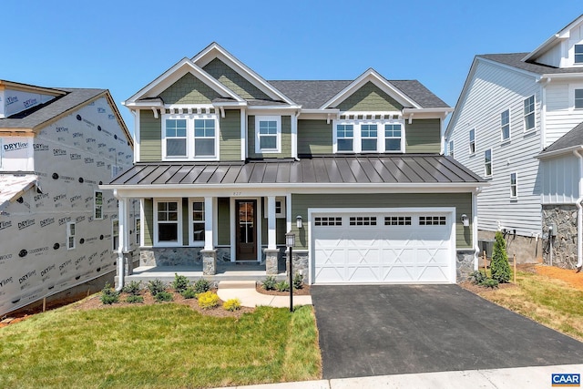 craftsman-style house featuring a porch, a front yard, and a garage