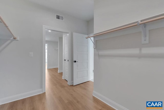 spacious closet with light hardwood / wood-style flooring