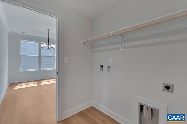 clothes washing area featuring hookup for an electric dryer, a notable chandelier, ornamental molding, light wood-type flooring, and hookup for a washing machine