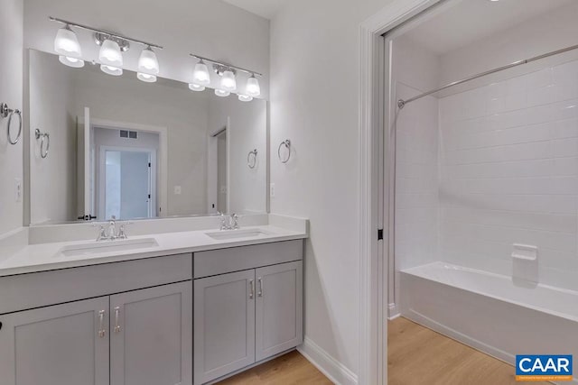 bathroom featuring hardwood / wood-style floors, vanity, and shower / bathtub combination