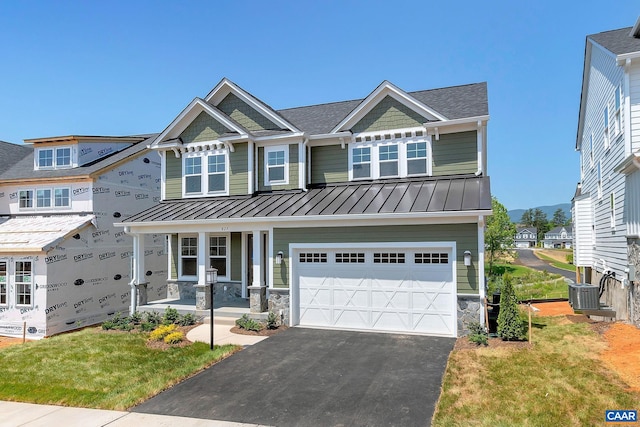 craftsman inspired home featuring a garage, central AC unit, and a front yard