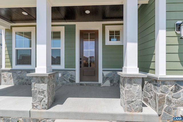 view of exterior entry featuring covered porch