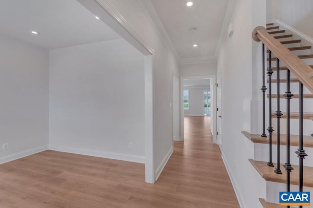 hallway featuring light hardwood / wood-style floors and crown molding