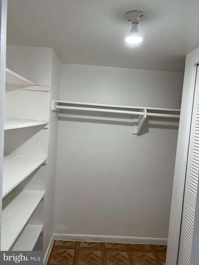 spacious closet with parquet flooring