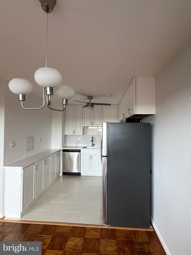 kitchen with sink, light tile patterned floors, appliances with stainless steel finishes, tasteful backsplash, and white cabinetry