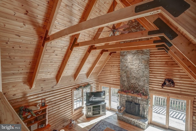 unfurnished living room featuring rustic walls, high vaulted ceiling, wood-type flooring, and wood ceiling