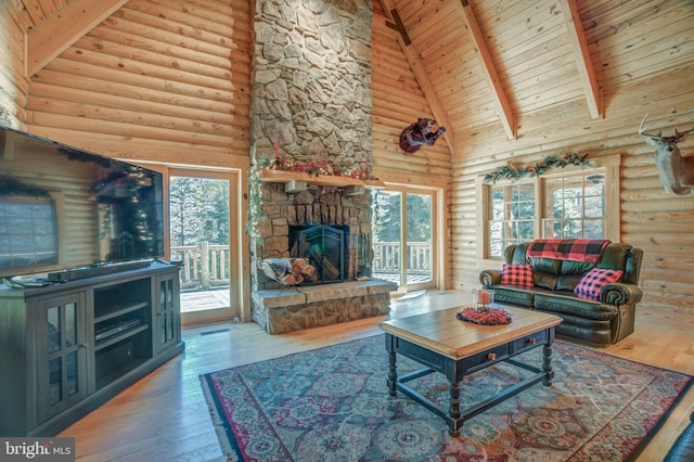 living room featuring high vaulted ceiling, plenty of natural light, hardwood / wood-style floors, and a fireplace