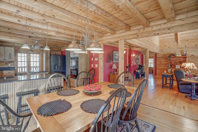 dining room featuring an inviting chandelier, wooden ceiling, beamed ceiling, light hardwood / wood-style flooring, and log walls