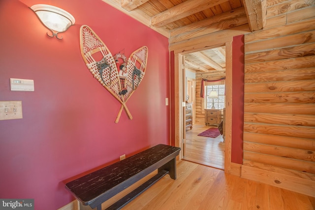 corridor featuring light hardwood / wood-style floors, beamed ceiling, log walls, and wood ceiling