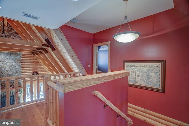 stairway with wood-type flooring and vaulted ceiling