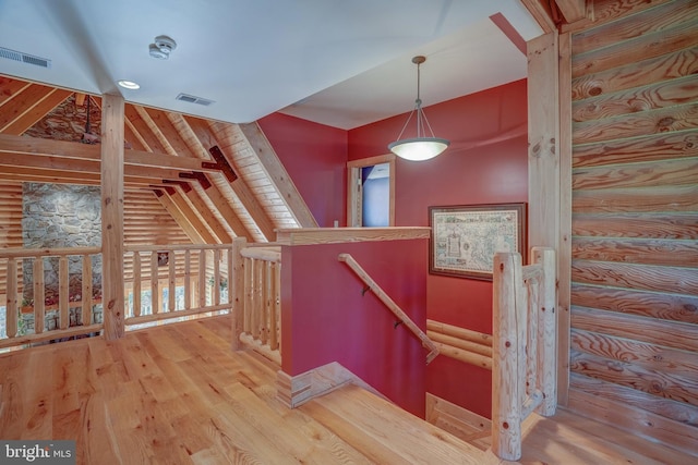 staircase featuring rustic walls and wood-type flooring