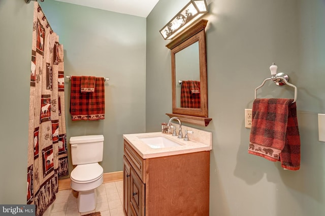 bathroom with toilet, vanity, and tile patterned floors