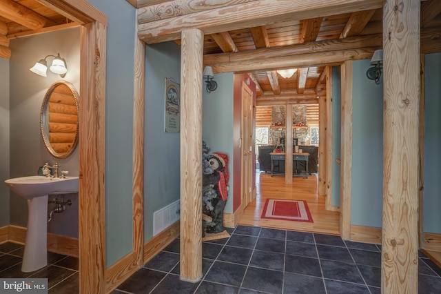 corridor with wooden ceiling, dark hardwood / wood-style floors, and beamed ceiling