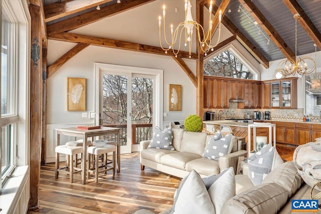 living room featuring high vaulted ceiling, beamed ceiling, and a healthy amount of sunlight