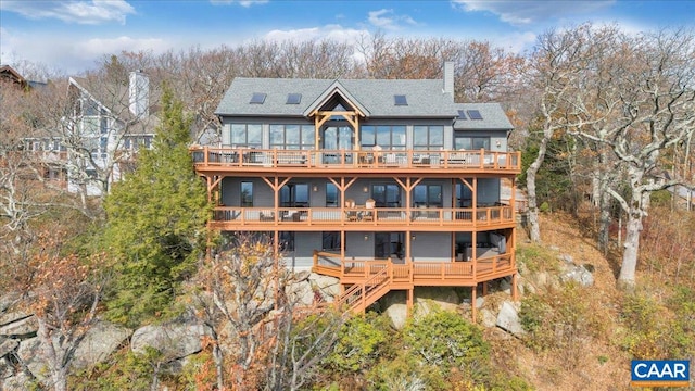 back of house featuring a wooden deck and a balcony