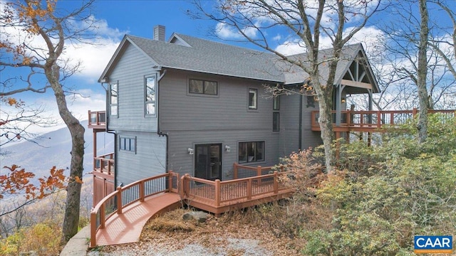 rear view of property featuring a deck with mountain view