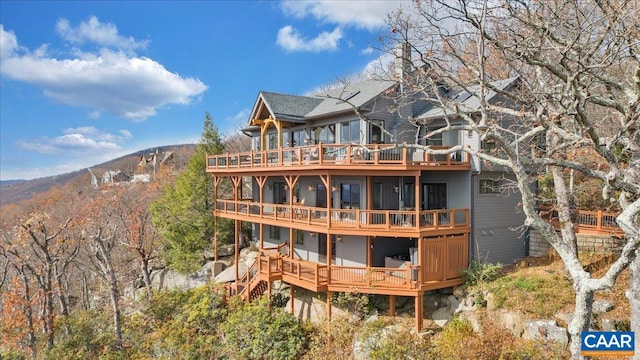 back of house featuring a mountain view and a balcony