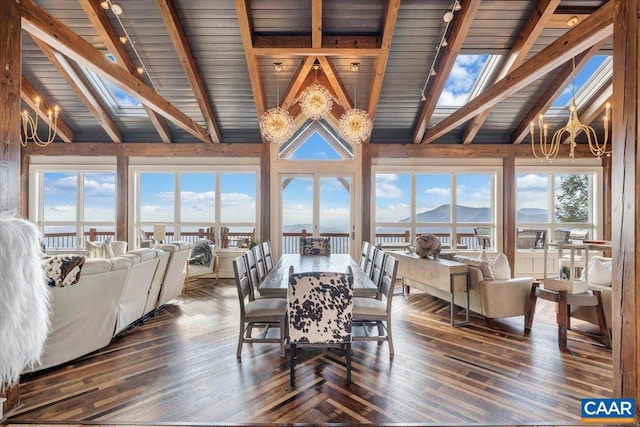 dining area featuring dark hardwood / wood-style flooring, a healthy amount of sunlight, high vaulted ceiling, a skylight, and a mountain view