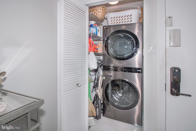 clothes washing area featuring stacked washer and clothes dryer