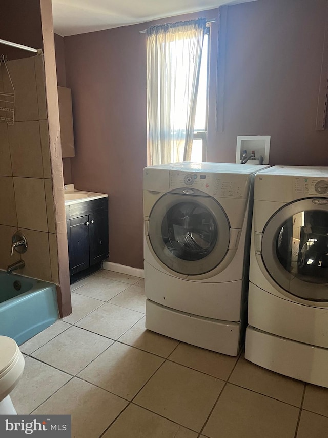 laundry area with separate washer and dryer and light tile patterned floors