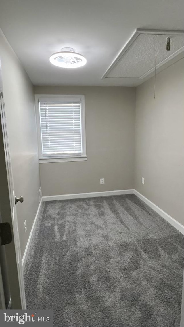 spare room with dark colored carpet