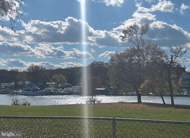 view of home's community with a water view and a lawn