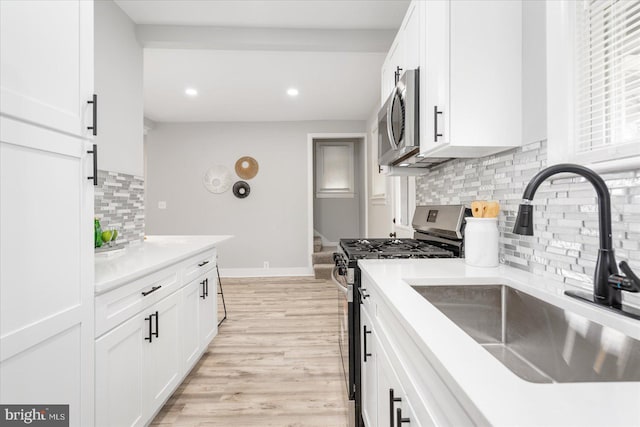 kitchen featuring white cabinets, sink, stainless steel appliances, and tasteful backsplash