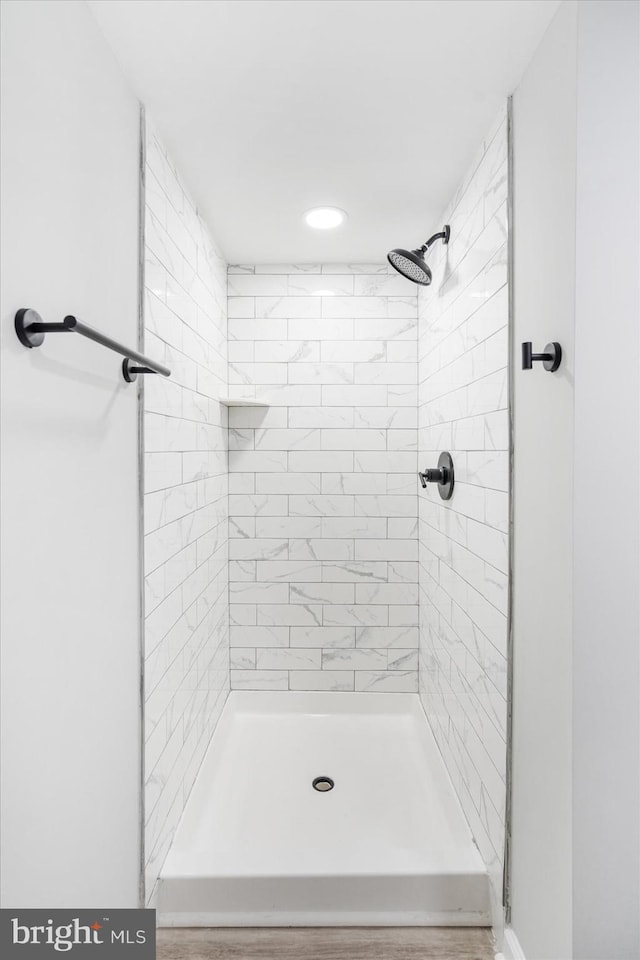 bathroom featuring hardwood / wood-style floors and a tile shower