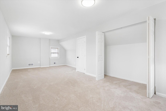 additional living space featuring light carpet and lofted ceiling