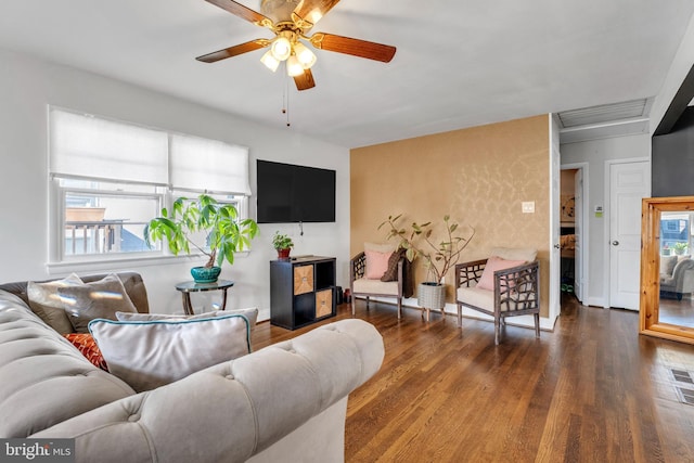 living room featuring ceiling fan and dark wood-type flooring