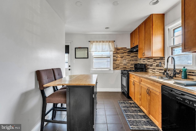 kitchen with black appliances, a kitchen breakfast bar, sink, tasteful backsplash, and a kitchen island