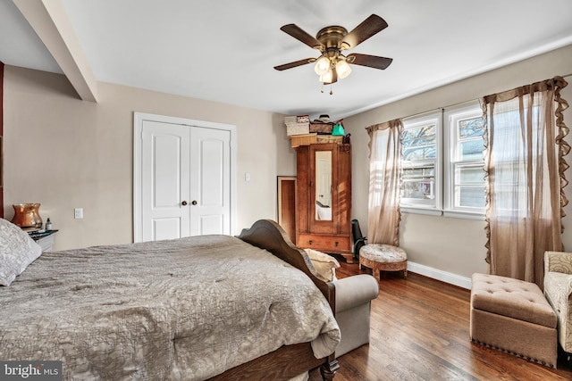 bedroom with ceiling fan, dark hardwood / wood-style flooring, and a closet