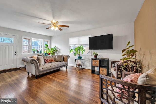 living room featuring ceiling fan and dark wood-type flooring