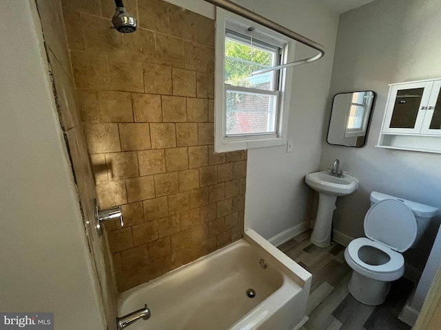 full bathroom with toilet, sink, tiled shower / bath combo, and wood-type flooring