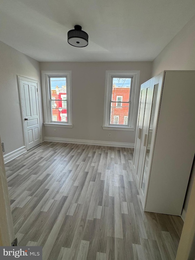 spare room featuring a wealth of natural light and light hardwood / wood-style flooring