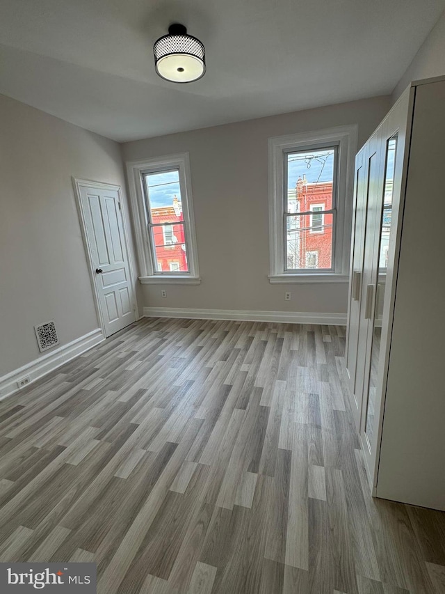 unfurnished room with light wood-type flooring and a wealth of natural light