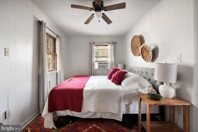 bedroom featuring ceiling fan, cooling unit, wood-type flooring, and wood walls