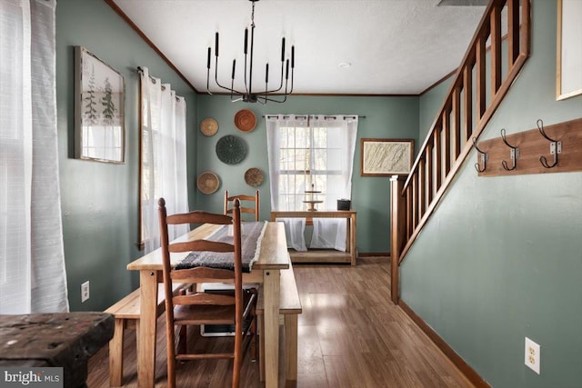 dining space featuring hardwood / wood-style flooring, crown molding, and a chandelier