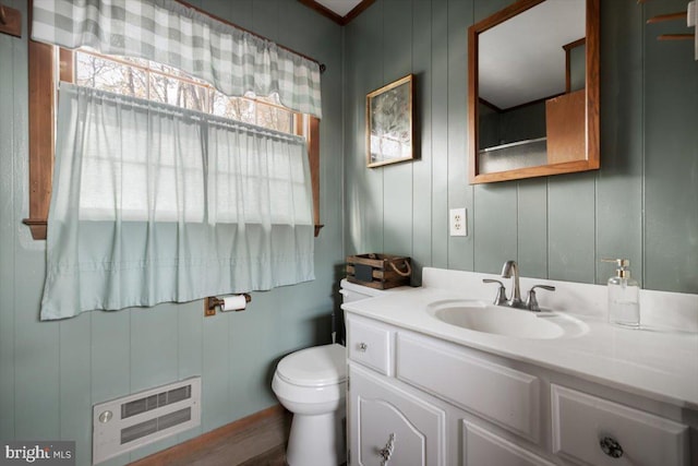 bathroom with wood walls, vanity, and toilet