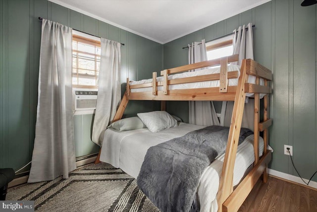 bedroom with cooling unit, crown molding, and dark wood-type flooring