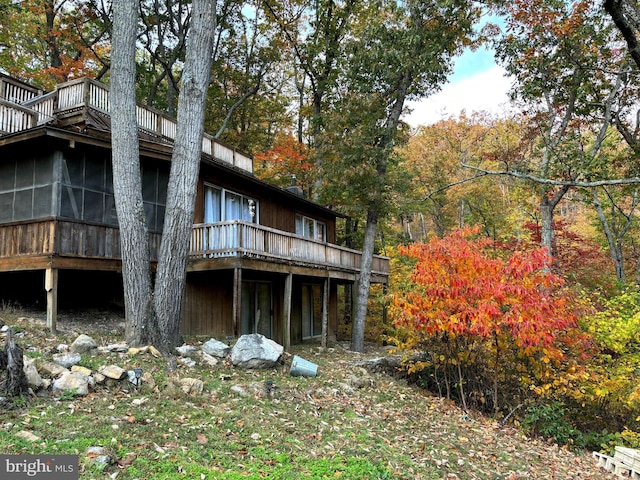 view of side of home with a deck and a sunroom