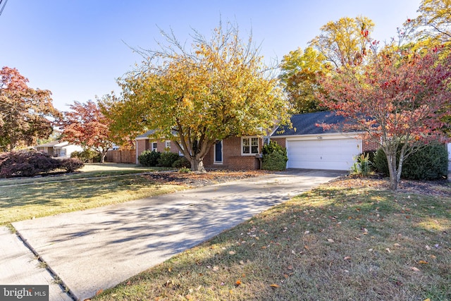 view of property hidden behind natural elements with a garage and a front yard