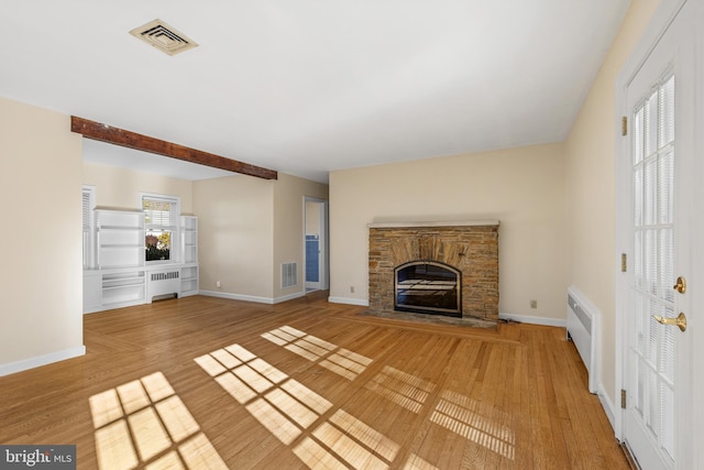 unfurnished living room featuring radiator, hardwood / wood-style floors, and a fireplace