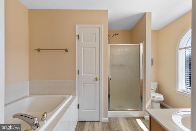 full bathroom with hardwood / wood-style floors, vanity, toilet, and independent shower and bath