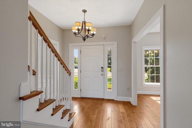 foyer entrance featuring a chandelier and light hardwood / wood-style flooring