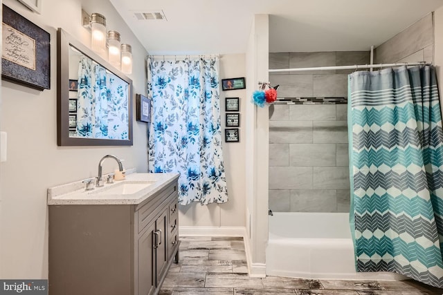 bathroom featuring hardwood / wood-style floors, vanity, and shower / tub combo