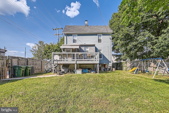 back of house with a playground, a yard, and a wooden deck