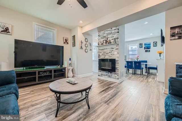 living room with a fireplace, hardwood / wood-style flooring, and ceiling fan