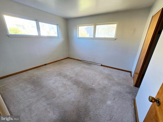 carpeted empty room with a baseboard heating unit